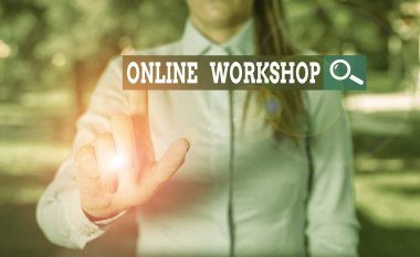 Writing note showing Online Workshop. Business photo showcasing intensive discussion and activity on a particular subject Woman in a blue shirt pointing with her finger into empty space.