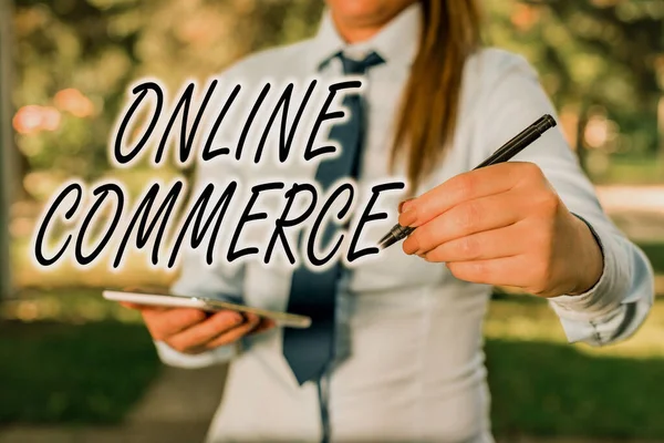 Handwriting text writing Online Commerce. Concept meaning activity of buying or selling of products on online services Woman in a blue business shirts pointing with her finger into empty space. — Stock Photo, Image