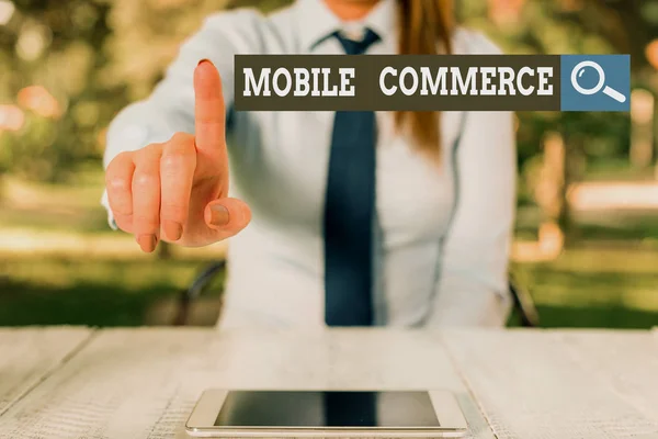 Word writing text Mobile Commerce. Business concept for all online commercial transactions using smartphones Female business person sitting by table and holding mobile phone. — Stock fotografie