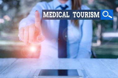 Sözcük yazma tıbbi turizmi. Sağlık hizmeti almak için ülke dışına seyahat konsepti. Masa başında oturan ve cep telefonu tutan kadın işadamı..