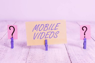 Mobil Videoları gösteren kavramsal el yazısı. İş metni elektronik medya görüntülenir veya cep telefonlarında kullanılır. Ahşap masaya ataç yerleştirilmiş kağıt levhalar parçalanır..