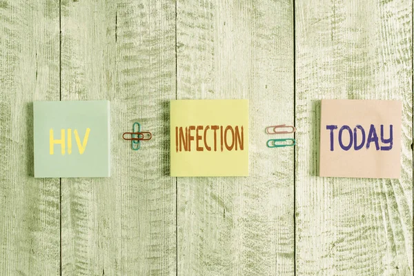 Text sign showing Hiv Infection. Conceptual photo sexually transmitted infection and a chronic disease Pastel colour note paper placed next to stationary above the wooden table.
