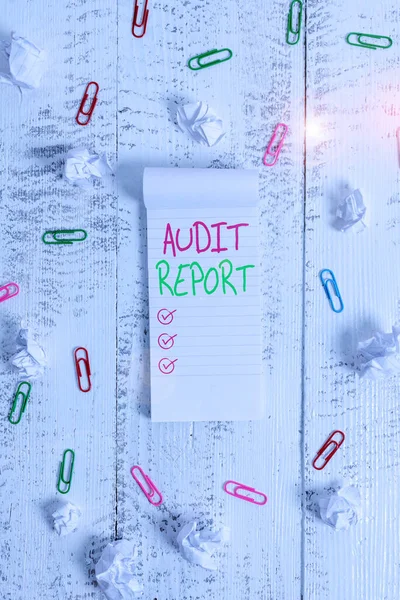 Conceptual hand writing showing Audit Report. Business photo showcasing Written opinion of an auditor about companys financial status Stripped ruled notepad clips paper balls wooden background. — Stockfoto