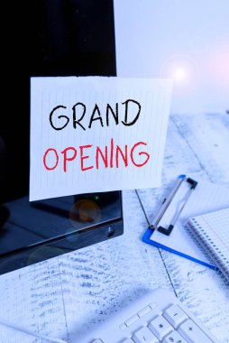 Büyük Açılışı gösteren bir not yazıyorum. Yeni bir işletme veya halka açık bir yerin açılışı için düzenlenen iş fotoğrafı sergisi. Klavye ve durağan yakınlarındaki siyah bilgisayar ekranına bantlanmış not kağıdı.
