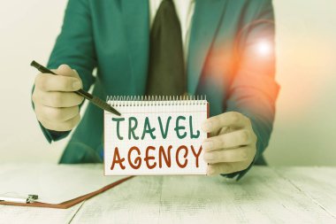 Seyahat acentesini gösteren bir mesaj. Gezginler için gerekli düzenlemeleri yapan kavramsal fotoğraf ajansı önünde fotokopi alanı olan boş bir kağıt tutuyor. Boşluğu kopyala.