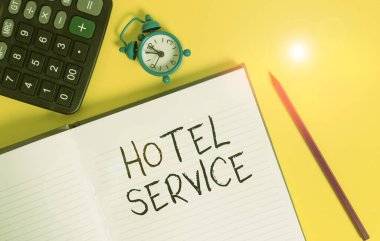 Otel servisini gösteren bir not yazıyorum. Konuklara sıcak konaklama ve diğer hizmetleri sunan iş fotoğrafı gösterimi Çizgili çizgili defter hesap makinesi metal alarm saat rengi arkaplan.