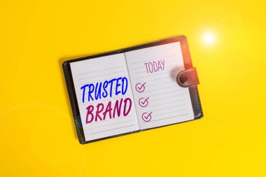 Güvenilir Brand 'in el yazısı. Tüketici kavramı, tüketicinin bütünlüğüne ve markasının yeteneğine inanması anlamına gelir. Koyu deri, kilitli, çizgili, kağıt çizgili, arka plan renkli..
