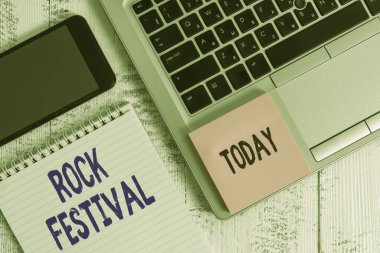Rock Festivali 'ni gösteren kavramsal el yazısı. Ağır metaller türünde dizüstü bilgisayarın yer aldığı büyük ölçekli rock müzik konserinin yer aldığı iş fotoğrafı ahşap masada nota akıllı telefon yapışkan nota yönetti..