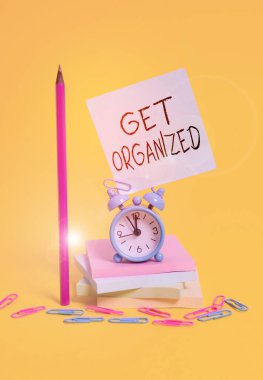 Get Organize 'i gösteren bir not yazıyorum. Özel bir sisteme göre düzenlenmiş iş fotoğrafı gösterimi tutarlı birlik saati yapış yapış not defterleri kalem renkli arkaplan.