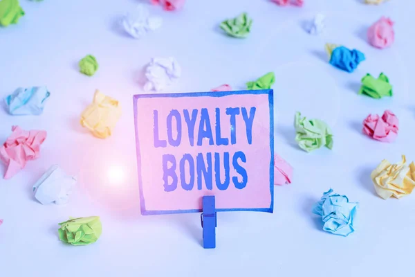 Text sign showing Loyalty Bonus. Conceptual photo reward such as money or points is given for a loyal customer Colored crumpled papers empty reminder white floor background clothespin. — Stock Fotó