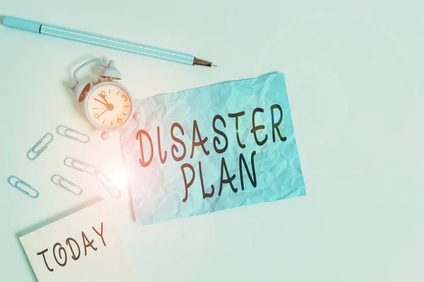 Handwriting text writing Disaster Plan. Concept meaning outlines how an organization responds to an unplanned event Alarm clock clips notepad blank crushed sheet marker sky colored background. — Stock Photo, Image