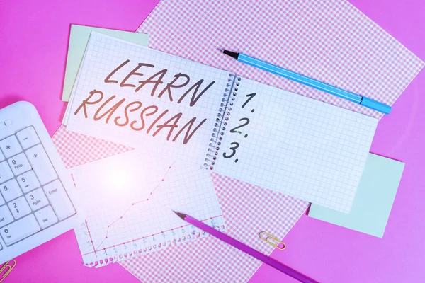 Conceptual hand writing showing Learn Russian. Business photo showcasing gain or acquire knowledge of speaking and writing Russian Writing equipments and computer stuff placed on plain table. — Stock Photo, Image