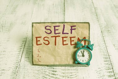 Word writing text Self Esteem. Business concept for a feeling of having respect for yourself and your abilities Mini blue alarm clock stand tilted above buffer wire in front of notepaper. clipart