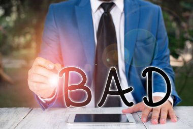 El yazısı kötü yazılmış. Kavram, ahlaki açıdan yanlış etkilerini gösteren nahoş şeyler demektir. İş adamı elinde kalem tutuyor ve kopya alanına işaret ediyor..