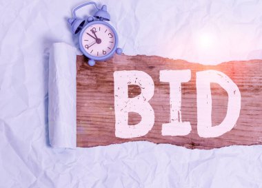 Kelime yazma teklifi. Satılık bir şey için belirli bir miktar para önermek için iş konsepti Alarm saati ve yırtık karton tahta bir masa arkaplanı üzerine yerleştirilir.