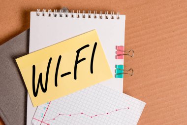 Wi-Fi 'ı gösteren bir not yazıyorum. İş fotoğraflarında radyo teknolojileri genellikle kablosuz yerel ağlar için kullanılır. Masa başı kağıt ofis kağıt ofis kağıt malzeme çalışma şeması..