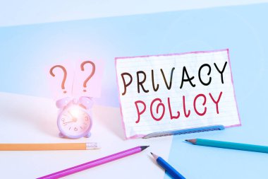 Gizlilik Politikasını gösteren metin işareti. Kavramsal fotoğraf beyanı ya da müşterilere bilgi veren yasal bir belge. Pastel arkaplana yaslanmış sabit bir arkaplan yanında Mini boyutunda alarm saati..