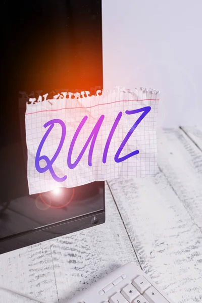 Signe texte montrant Quiz. Photo conceptuelle Bref test informel donné aux étudiants Test de connaissances Examen Papier de notation collé à l'écran noir de l'ordinateur près du clavier blanc . — Photo