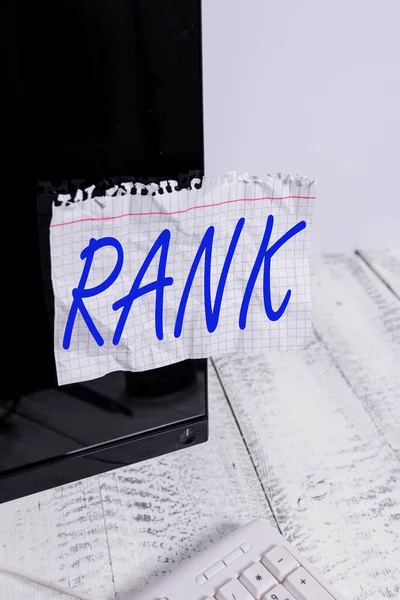 Text sign showing Rank. Conceptual photo The showing or things that belong to a particular organization or group Notation paper taped to black computer monitor screen near white keyboard. — Stock Photo, Image