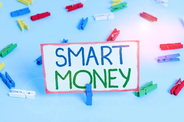 Handwriting text Smart Money. Concept meaning the money bet or invested by showing with expert knowledge Colored clothespin papers empty reminder blue floor background office pin.