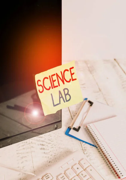 Writing note showing Science Lab. Business photo showcasing special facility where experiments are done and with equipment Note paper taped to black computer screen near keyboard and stationary.