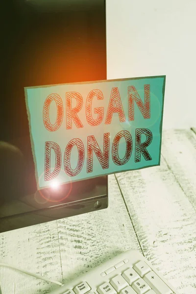 Word writing text Organ Donor. Business concept for the act of donating an organ to a demonstrating needed a transplant Notation paper taped to black computer monitor screen near white keyboard.
