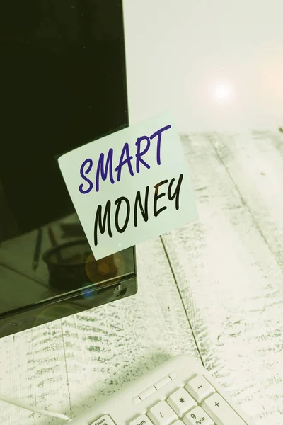 Handwriting text writing Smart Money. Concept meaning the money bet or invested by showing with expert knowledge Notation paper taped to black computer monitor screen near white keyboard.