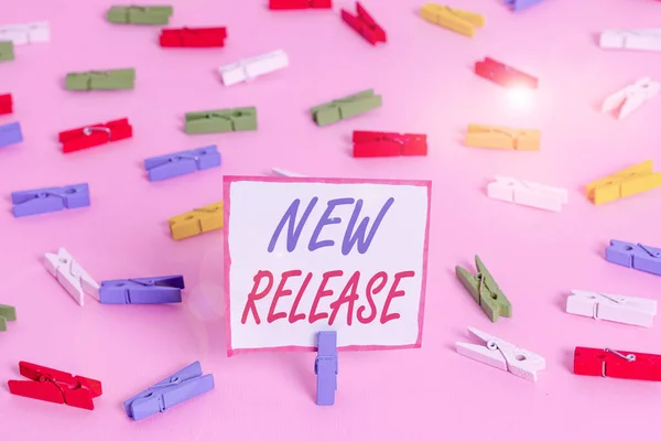 Conceptual hand writing showing New Release. Business photo showcasing announcing something newsworthy recent product in the market Colored clothespin papers empty reminder pink floor office. — Stock Photo, Image