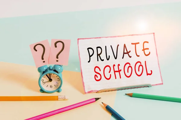 Text sign showing Private School. Conceptual photo an independent school supported wholly by the payment of fees Mini size alarm clock beside stationary placed tilted on pastel backdrop.