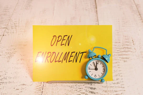 Writing note showing Open Enrollment. Business photo showcasing policy of allowing qualifying students to enroll in school Alarm clock tilted above buffer wire in front of notepaper. — Stock Photo, Image