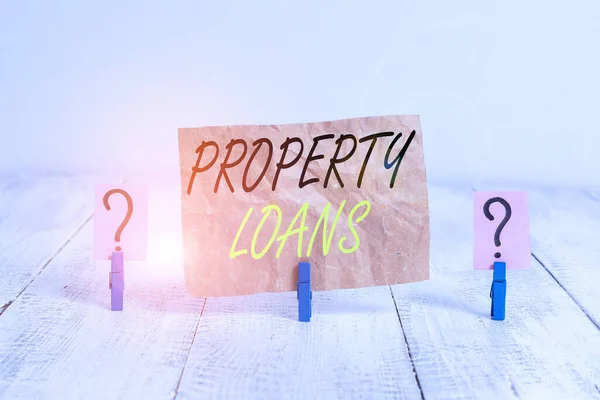 Word writing text Property Loans. Geschäftskonzept für einen Kredit zum Kauf von Land oder Gebäuden und Infrastrukturen Gekritzeltes und bröckelndes Blatt mit Büroklammern auf dem Holztisch. — Stockfoto