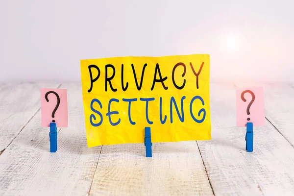 Gizlilik Ayarlarını gösteren not yazılıyor. İş fotoğrafı gösterimi profil erişimini sınırlandırır ve ahşap masaya yerleştirilmiş ataçlarla hangi bilgilerin parçalandığını görebilir.