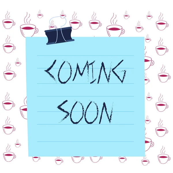 Writing note showing Coming Soon. Business photo showcasing something is going to happen soon or after a short time Paper lines binder clip suare notebook color background.