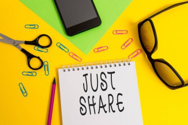 Writing note showing Just Share. Business photo showcasing to have or use something at the same time as someone else Sheet pencil smartphone scissors eyeglasses notepad color background.