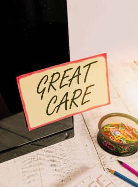 Writing note showing Great Care. Business photo showcasing to treat someone with great or excessive care or kindness Note paper taped to black computer screen near keyboard and stationary.