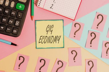Handwriting text writing Gig Economy. Concept meaning free market system in which temporary positions are common Mathematics stuff and writing equipment above pastel colours background. clipart