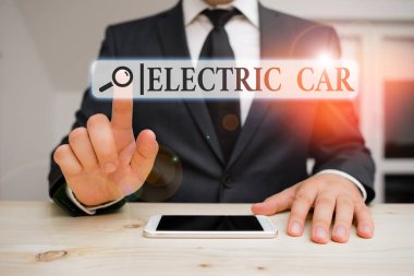 Kelimelerle yazılan elektrikli araba. Bir veya daha fazla elektrik motoru tarafından itilen bir otomobil için iş konsepti. Erkek insan resmi kıyafetler giyer. Sunum için yüksek teknoloji akıllı telefonu kullanın..