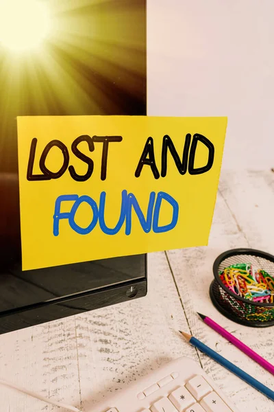 Signo de texto que muestra Lost And Found. Foto conceptual un lugar donde los objetos perdidos se almacenan hasta que reclaman Nota papel pegado a la pantalla del ordenador negro cerca del teclado y estacionario . —  Fotos de Stock