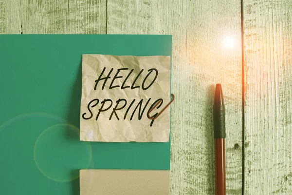 Text sign showing Hello Spring. Conceptual photo welcoming the season of the blossoming of flowers End of winter Wrinkle paper and cardboard plus stationary placed above wooden background. — Stock Photo, Image