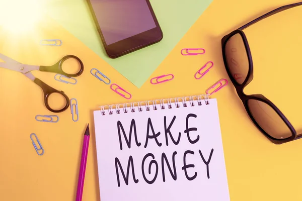 Writing note showing Make Money. Business photo showcasing making a profit or giving the opportunity to make a profit Sheet pencil smartphone scissors eyeglasses notepad color background. — Stockfoto