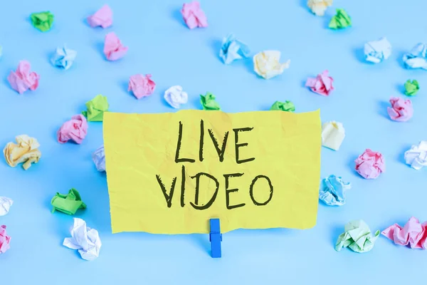 Handwriting text writing Live Video. Concept meaning broadcast a live video or streamingfeed to an online audience Colored crumpled papers empty reminder blue floor background clothespin.