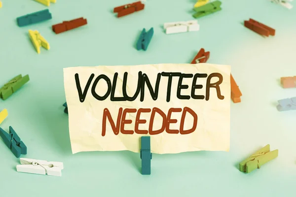 Text sign showing Volunteer Needed. Conceptual photo asking demonstrating to work for organization without being paid Colored clothespin papers empty reminder blue floor background office pin. — ストック写真