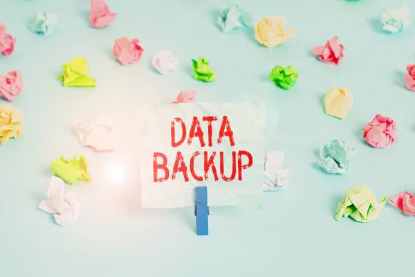 Handwriting text Data Backup. Concept meaning copy of important data that is stored on an alternative location Colored crumpled papers empty reminder blue floor background clothespin. — Φωτογραφία Αρχείου
