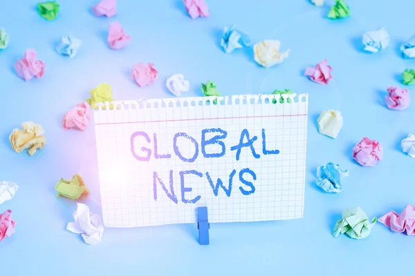 Conceptueel handschrift met Global News. Zakelijke foto presentatie wereld opmerkelijke informatie over recente of belangrijke gebeurtenissen Gekleurde verfrommelde papieren lege herinnering blauwe vloer wasknijper. — Stockfoto