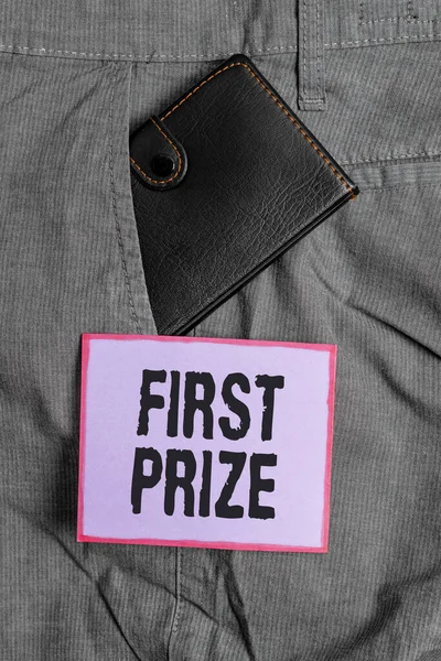 Text sign showing First Prize. Conceptual photo the most desirable or grand prize offered for the overall winner Small little wallet inside man trousers front pocket near notation paper.
