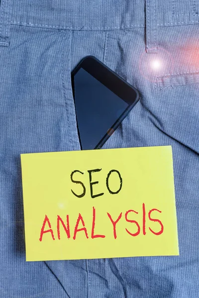 Word writing text Seo Analysis. Business concept for tool helps showing to study on how to improve a website ranking Smartphone device inside formal work trousers front pocket near note paper.