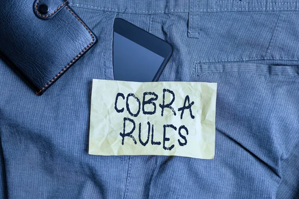 コブラ規則を示すメモを書く。仕事の損失の後の継続的なグループの健康保険カバーを紹介するビジネス写真財布付きズボンフロントポケット内のスマートフォンデバイス. — ストック写真
