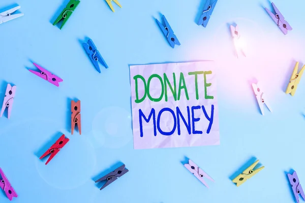 Text sign showing Donate Money. Conceptual photo to give money or goods to help a demonstrating or organization Colored clothespin rectangle shaped reminder paper light blue background. — Stock fotografie