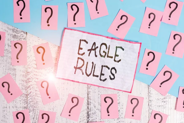 Handwriting text Eagle Rules. Concept meaning a huge set of design rules which your layout needs to pass Scribbled and crumbling papers with thick cardboard above wooden table. — ストック写真