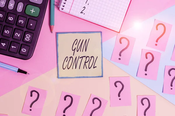 Handwriting text writing Gun Control. Concept meaning legal measure intended to restrict the possession of guns Mathematics stuff and writing equipment above pastel colours background.